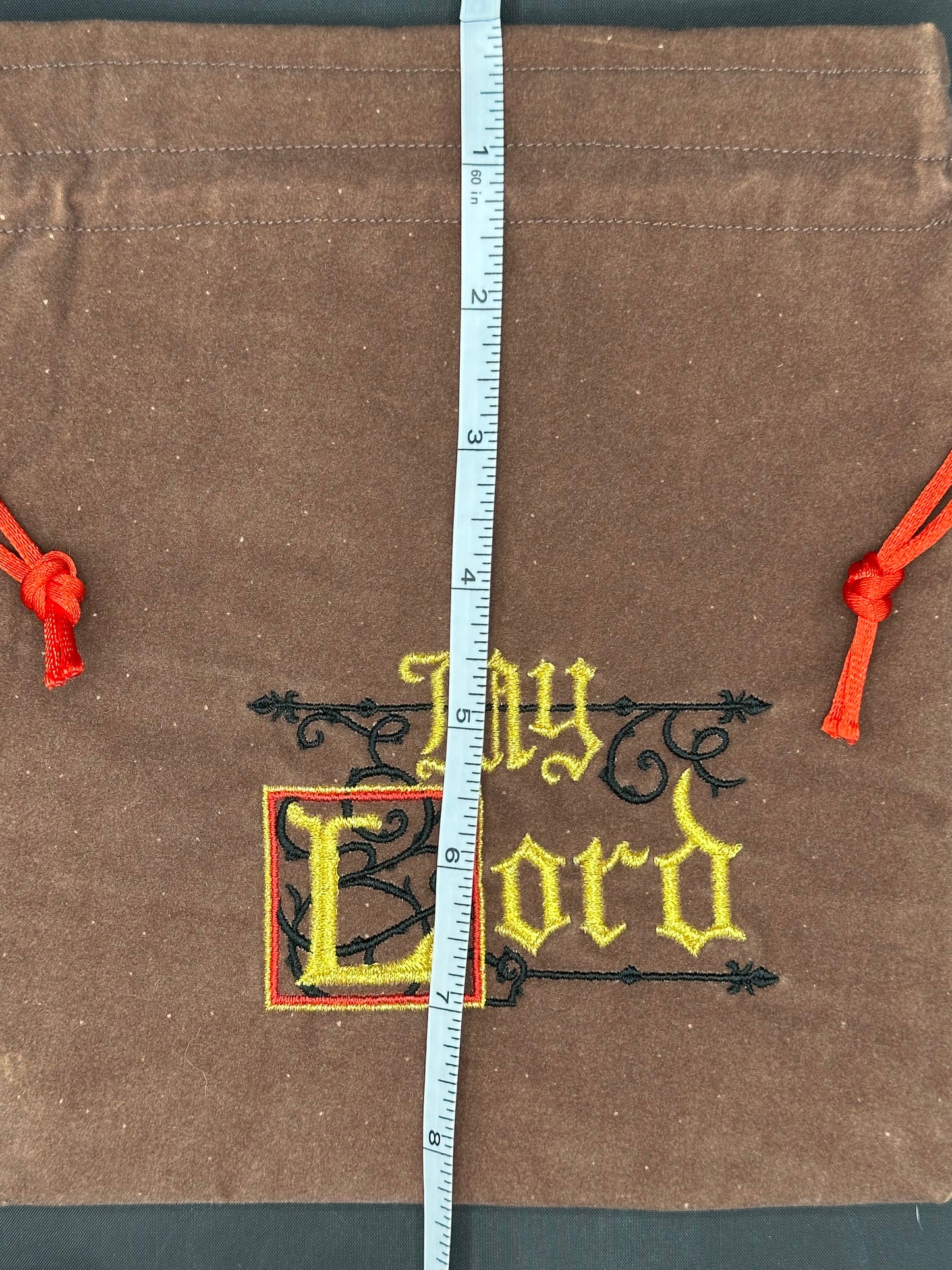 Embroidered My Lord on brown suede draw string bag